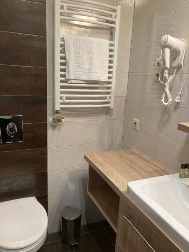 a bathroom with a white toilet and a sink at Zöld zafír in Sárvár