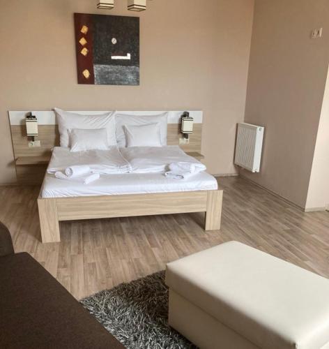 a bedroom with a bed with white sheets and pillows at Zöld zafír in Sárvár