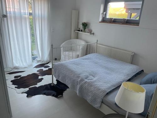a bedroom with a bed and a rug on the floor at Moderne Ferienwohnung in Strandnähe in Surendorf