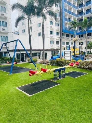 a park with a playground with a slide and scissors at King of kings at SEA RESIDENCES in Manila