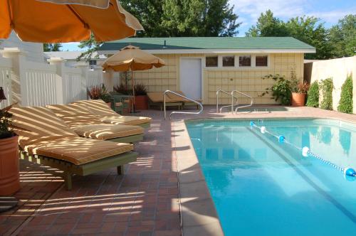 a swimming pool with lounge chairs and an umbrella at Tallman Hotel in Upper Lake