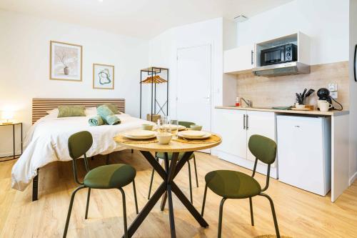 une chambre avec un lit et une table avec des chaises dans l'établissement Studio Elégant 3 pers wifi, à Saint-Quentin