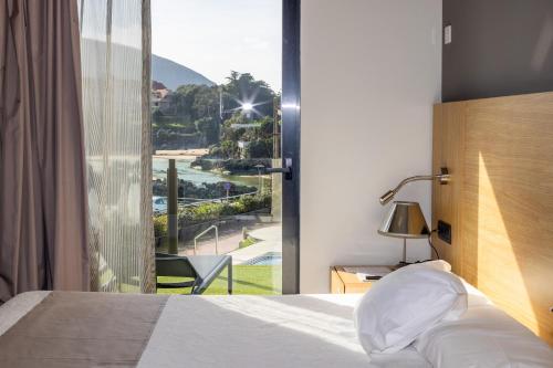 a bedroom with a bed and a window with a view at Hotel Astuy in Isla