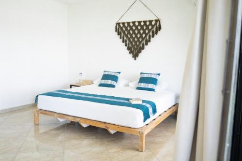 a bedroom with a bed with blue and white pillows at Yauik in Tequesquitengo
