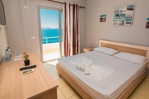 ein Schlafzimmer mit einem Bett und Meerblick in der Unterkunft Fly Hotel in Vlorë