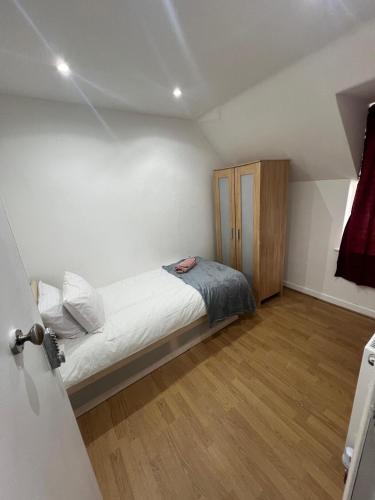 a small bedroom with a bed and a wooden cabinet at Good Priced Single Rooms in East Acton in London