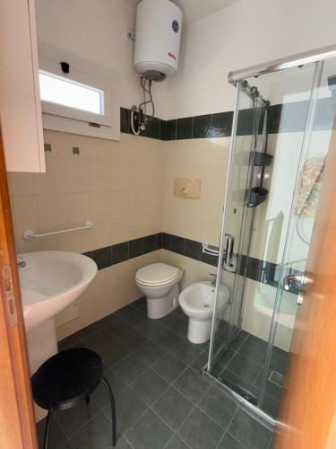 a bathroom with a shower and a toilet and a sink at Casa Vacanza Delfino in Porto Cesareo