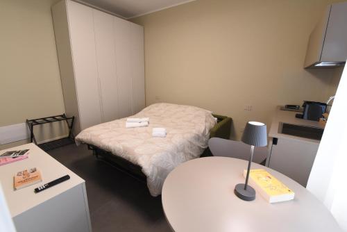 a small room with a bed and a table at Rooms de' Carracci in Bologna