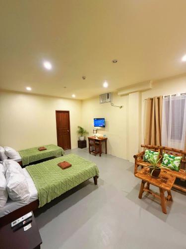 a hotel room with two beds and a desk at Adlaw Inn in Puerto Princesa City