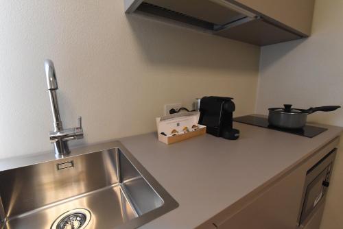a kitchen counter top with a sink and a stove at Rooms de' Carracci in Bologna