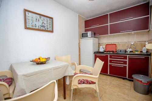a kitchen with a table and chairs in a room at Apartments Oliva in Utjeha