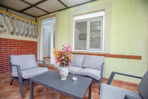 a patio with a table and chairs and a couch at Apartments Oliva in Utjeha