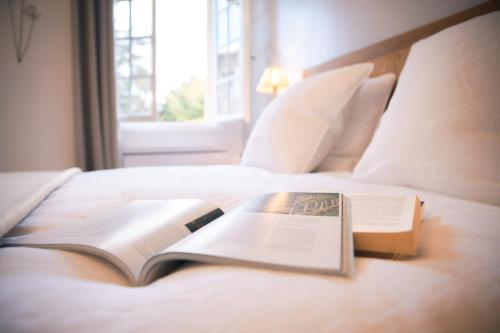 a book sitting on top of a bed at Patio des Rêves - Charme au cœur du Gers in Aujan-Mournède