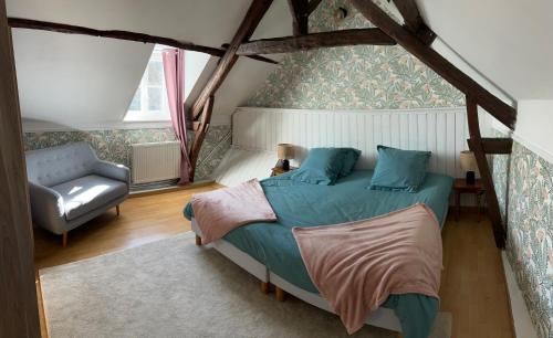 une chambre avec un lit et une chaise dans l'établissement Longère à la campagne, à Montigny-Lengrain