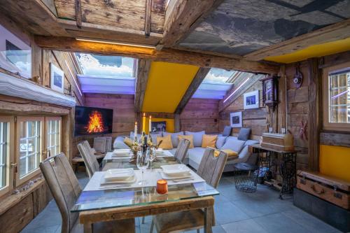 a dining room with a table and a couch at Chalet Schtuba in Zermatt