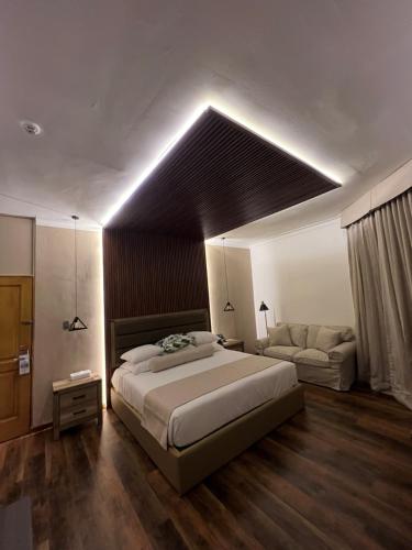 a bedroom with a large bed and a couch at Gran Hotel Europa Santo Domingo Trademark Collection by Wyndham in Santo Domingo