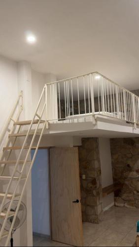 a white staircase in a room with a stone wall at Yauik in Tequesquitengo