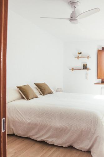 a white bedroom with a white bed and a ceiling at Cal Teixidor de Cartellà, Sant Gregori GIRONA in Sant Gregori