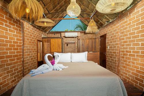 a bedroom with a bed with two swans on it at Kabañas & Beach Club Ojo de Agua in Puerto Morelos