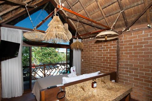 a room with a bed and a brick wall at Kabañas & Beach Club Ojo de Agua in Puerto Morelos