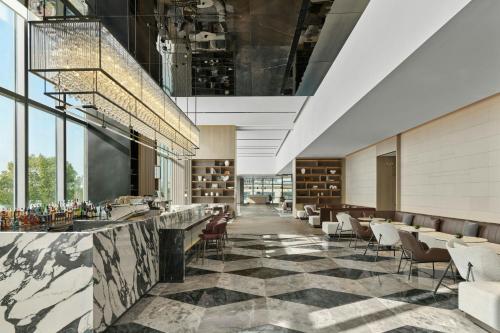 a lobby of a hotel with a bar and chairs at AC Hotel Suzhou Industrial Park in Suzhou