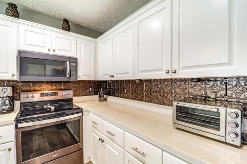 a kitchen with white cabinets and a microwave at 6 Mi to Skiing Mtn-View Condo in Seven Devils in Seven Devils