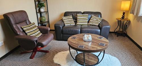 a living room with a couch and two chairs and a table at Ash Cottage in Stranraer