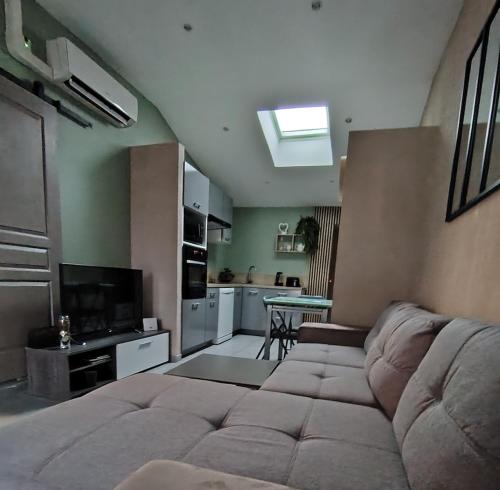 a living room with a couch and a kitchen at Ni 100%Gite,Ni100% loc chez Kheira&Pascal in Vitrolles