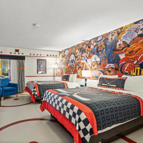 a bedroom with two beds and a wall with a football mural at Travelodge Hotel by Wyndham Saskatoon in Saskatoon