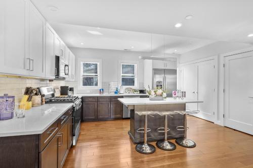 a large kitchen with white cabinets and a large island at 3BR2Bth TD Garden,MIT,Harvard,BOS,2 Parking Spaces in Somerville