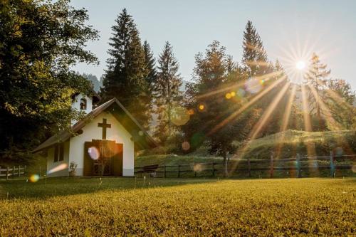 a white church with the sun shining on it at B&B Ai Marchetini in Cinte Tesino