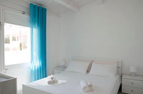 a white bedroom with a white bed and a window at Almaga Apartments - San Lorenzo, Marzamemi in Noto