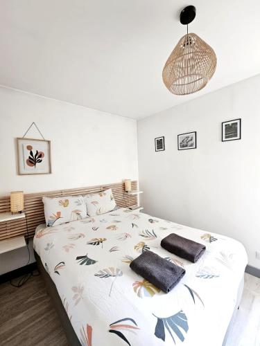 une chambre avec un lit avec des oreillers dessus dans l'établissement Evasion, Appartement avec terrasse, à Reims