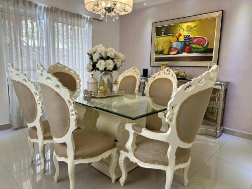 a dining room with a glass table and chairs at Casa en la Autopista de San Isidro in Hainamosa