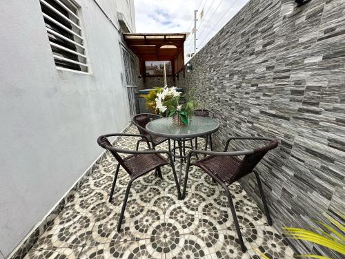 a table and chairs on a balcony with a brick wall at Casa en la Autopista de San Isidro in Hainamosa