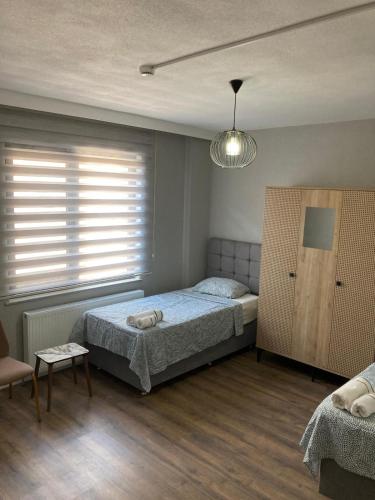 a bedroom with a bed and a chair and a window at Kabaklı Konaklama Turizm Amaçlı Kiralık Konut in Kabaklı