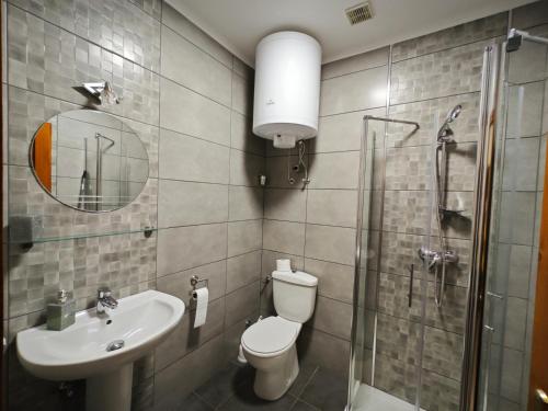 a bathroom with a toilet and a sink and a shower at Tavi Panzió in Dunapataj