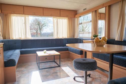 a living room with a blue couch and a table at Camping Cottesserhoeve in Vijlen