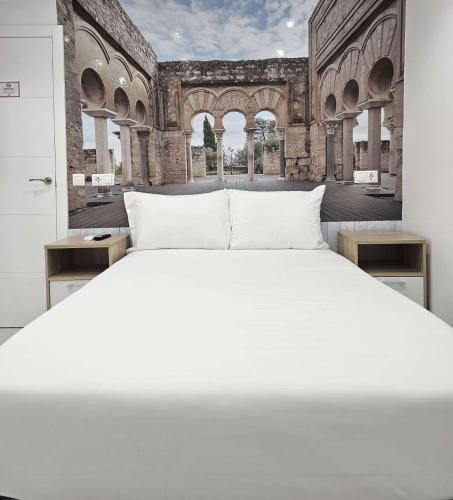 a bedroom with a white bed in a building at Nueva PENSION CIBELES in Córdoba