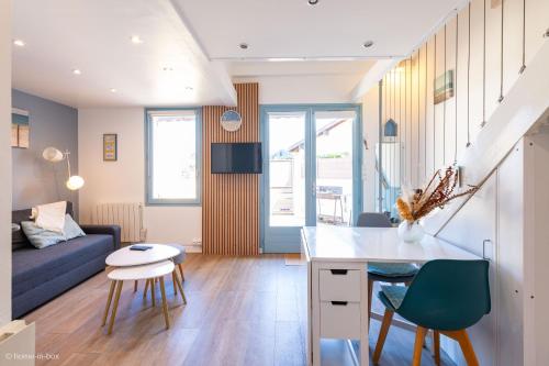 a kitchen and living room with a blue couch at Les Cottages 2 - Maison 4 à 5 personnes au bord de l'océan in Biscarrosse
