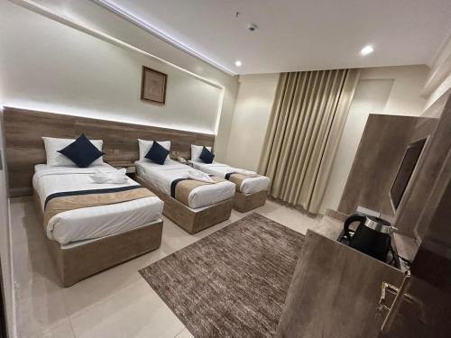 a hotel room with two beds and a rug at فندق النخبة الماسي - Diamond Elite Hotel in Al Madinah