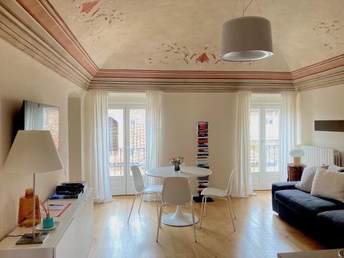 ein Wohnzimmer mit Tisch und Couch in der Unterkunft Appartamento in centro storico in Asti