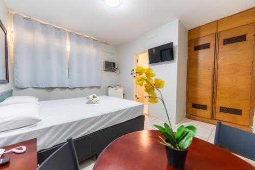 a small room with a bed and a table at Hotel Alvorada Taguatinga by Bsb Inn in Taguatinga