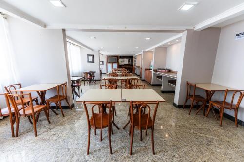 a group of tables and chairs in a room at Hotel Alvorada Taguatinga by Bsb Inn in Taguatinga