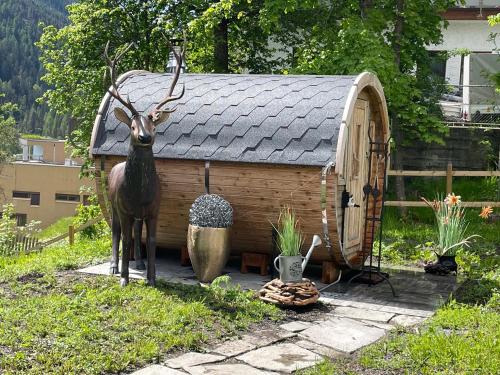 a statue of a deer standing in front of a dog house at Ferienhaus Meis Chalet in Scuol