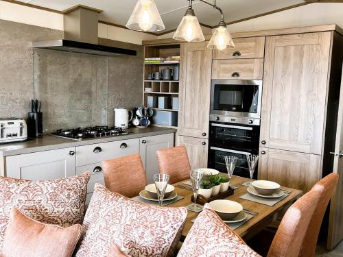 a kitchen with a wooden table with chairs and a dining room at Luxury 2 bedroom holiday home with stunning views in St. Andrews