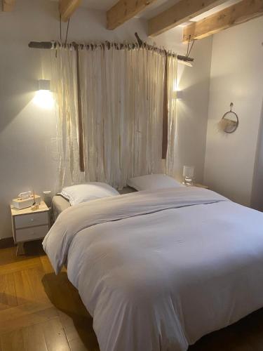 une chambre avec un grand lit blanc et une fenêtre dans l'établissement Maison chaleureuse, à Matemale