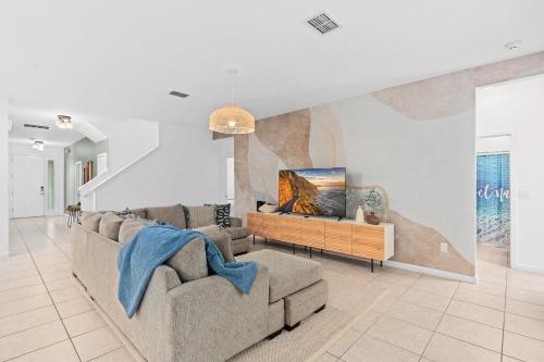a living room with two couches and a tv at SUPER BOHO 25 - 9BDR-7BAs SLEEP 22 wAMENITIEs in Kissimmee