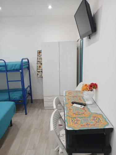 a room with a table and a tv and a bed at Green Garden da Virna 2 in Torre Annunziata