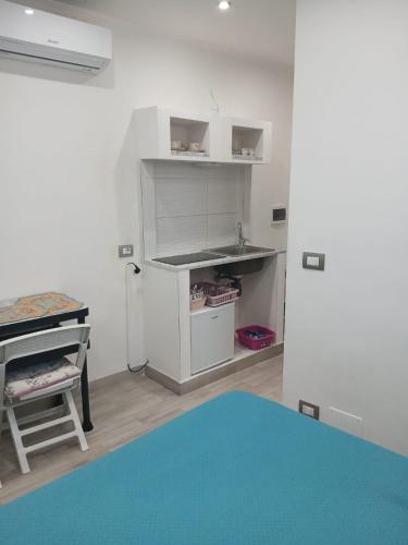a small kitchen with a refrigerator and a table at Green Garden da Virna 2 in Torre Annunziata